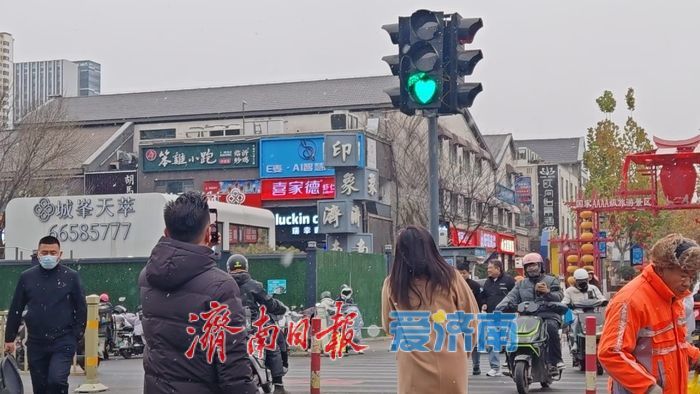 济南迎来今冬初雪 引行人驻足拍照留念