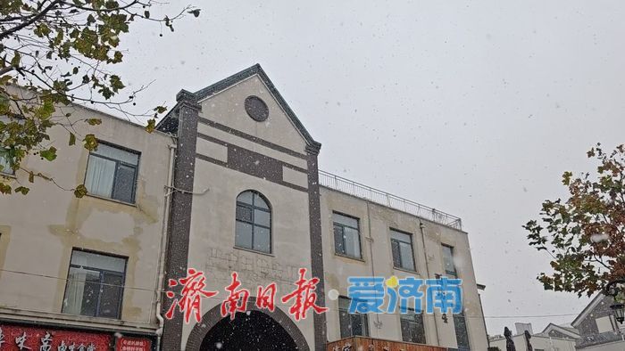 济南迎来今冬初雪 引行人驻足拍照留念