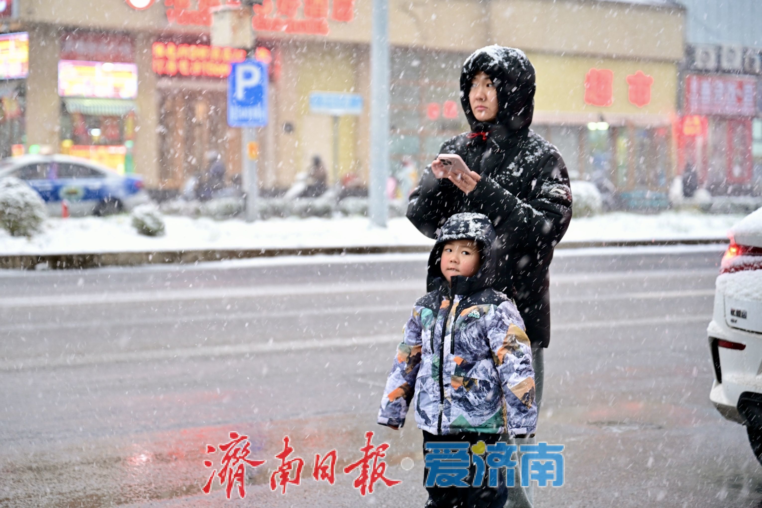 初雪扮靓泉城 行人驻足赏冬日浪漫