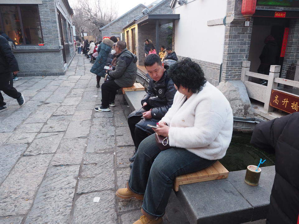 济南明府城泉河边，石栏新设木坐凳让游客听泉