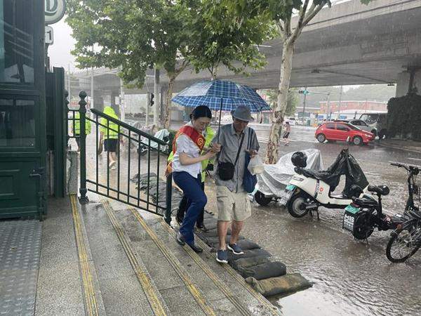 一幕触动人心的画面！地铁女员工暴雨天搬防洪沙袋获好评 