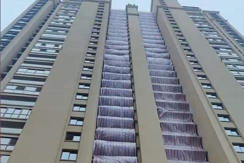 硬核防寒！阜阳一小区用雨布盖住高楼连廊，物业：为防止积雪和水管冻坏，每栋楼用掉200米雨布