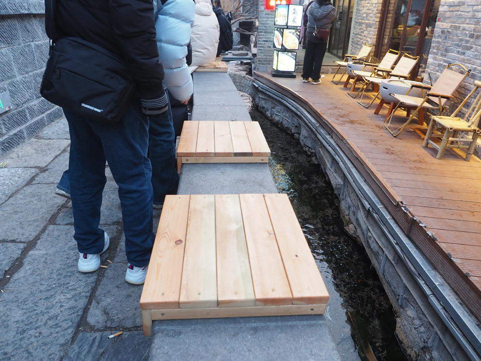 济南明府城泉河边，石栏新设木坐凳让游客听泉