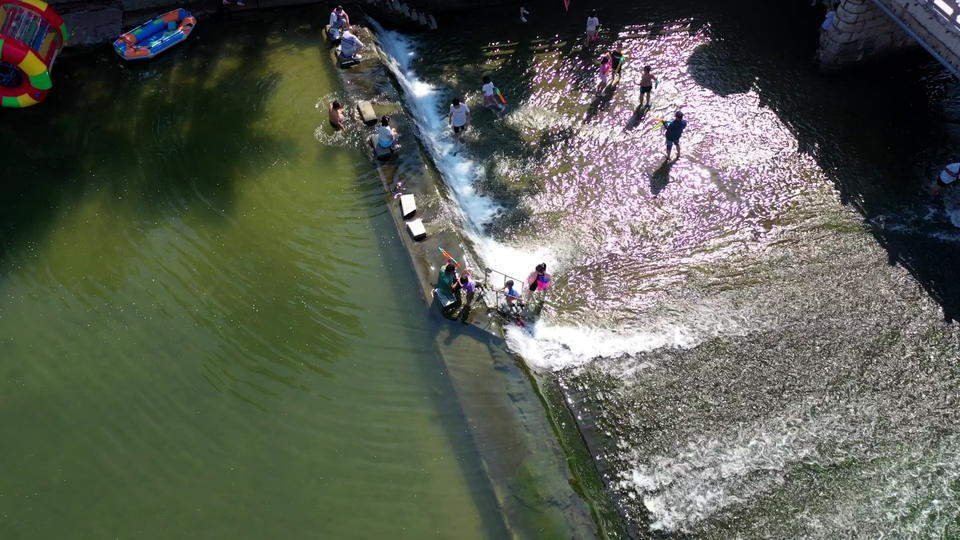 济南连续降雨后玉符河流水潺潺，孩子们尽情玩水