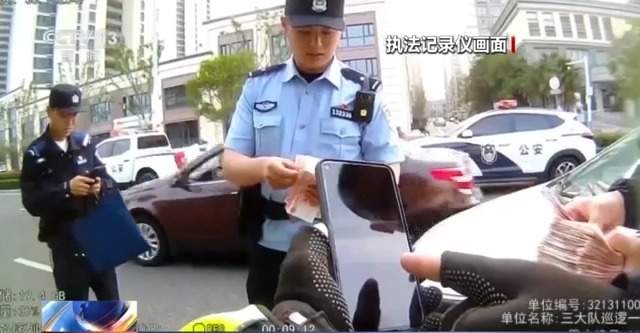 被遗忘在车顶的钱袋子“飞”出3万元 民警上演“马路寻金”