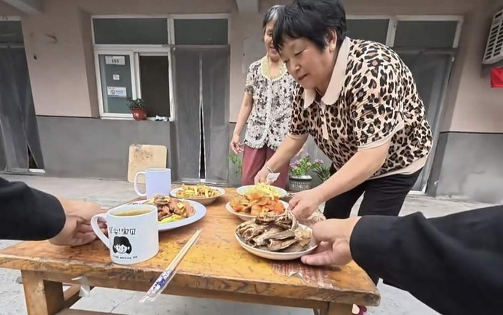山大毕业生为10名环卫工发红包，被请吃“百家饭”，一家出一盘菜，还为他打包水饺