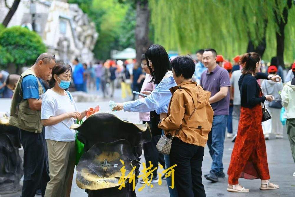 凉意来袭，市民游客换上秋装打卡护城河泉景