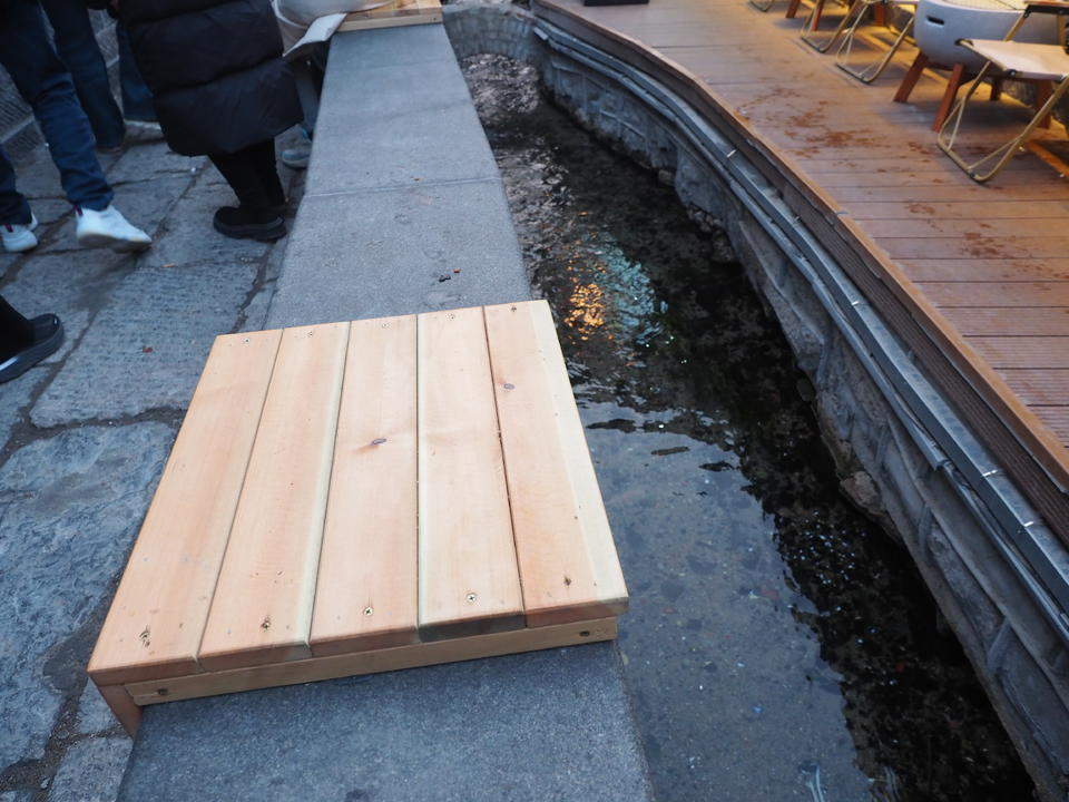 济南明府城泉河边，石栏新设木坐凳让游客听泉