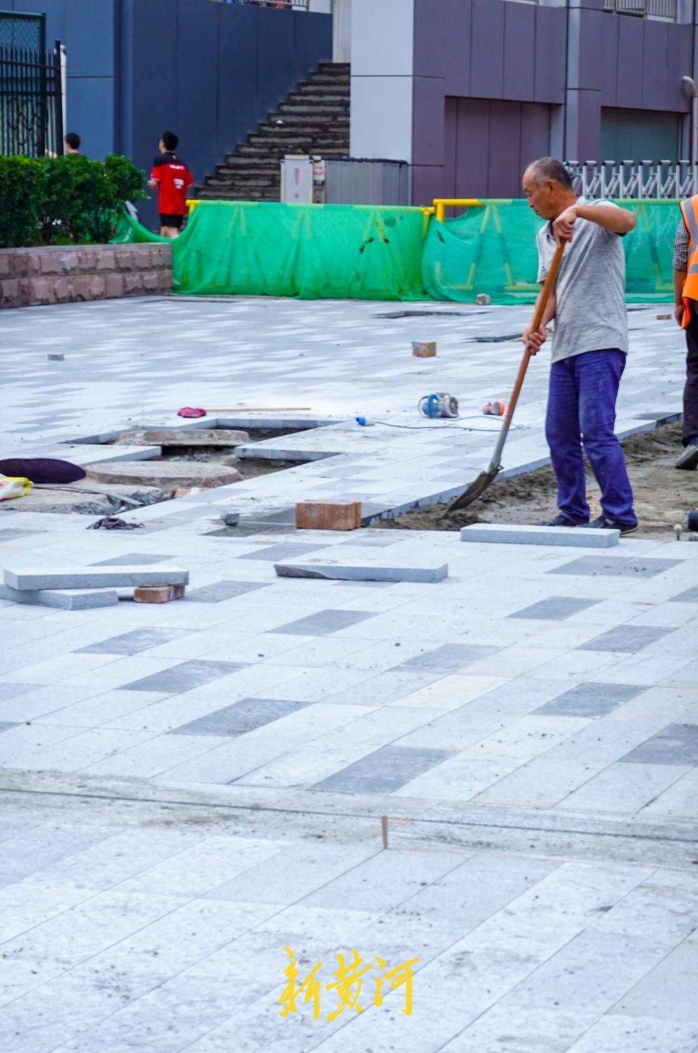 泉城路东段人行道启动石板铺装，深浅灰双色交替打造品质慢行空间