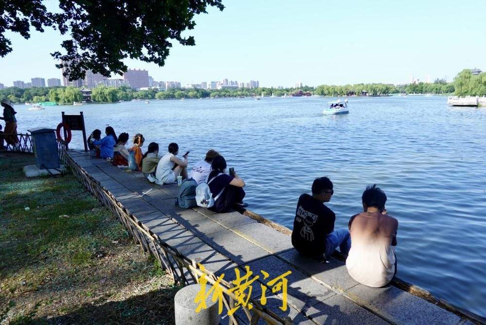 凉风习习，市民游客围坐湖堤享惬意“吹风时光”