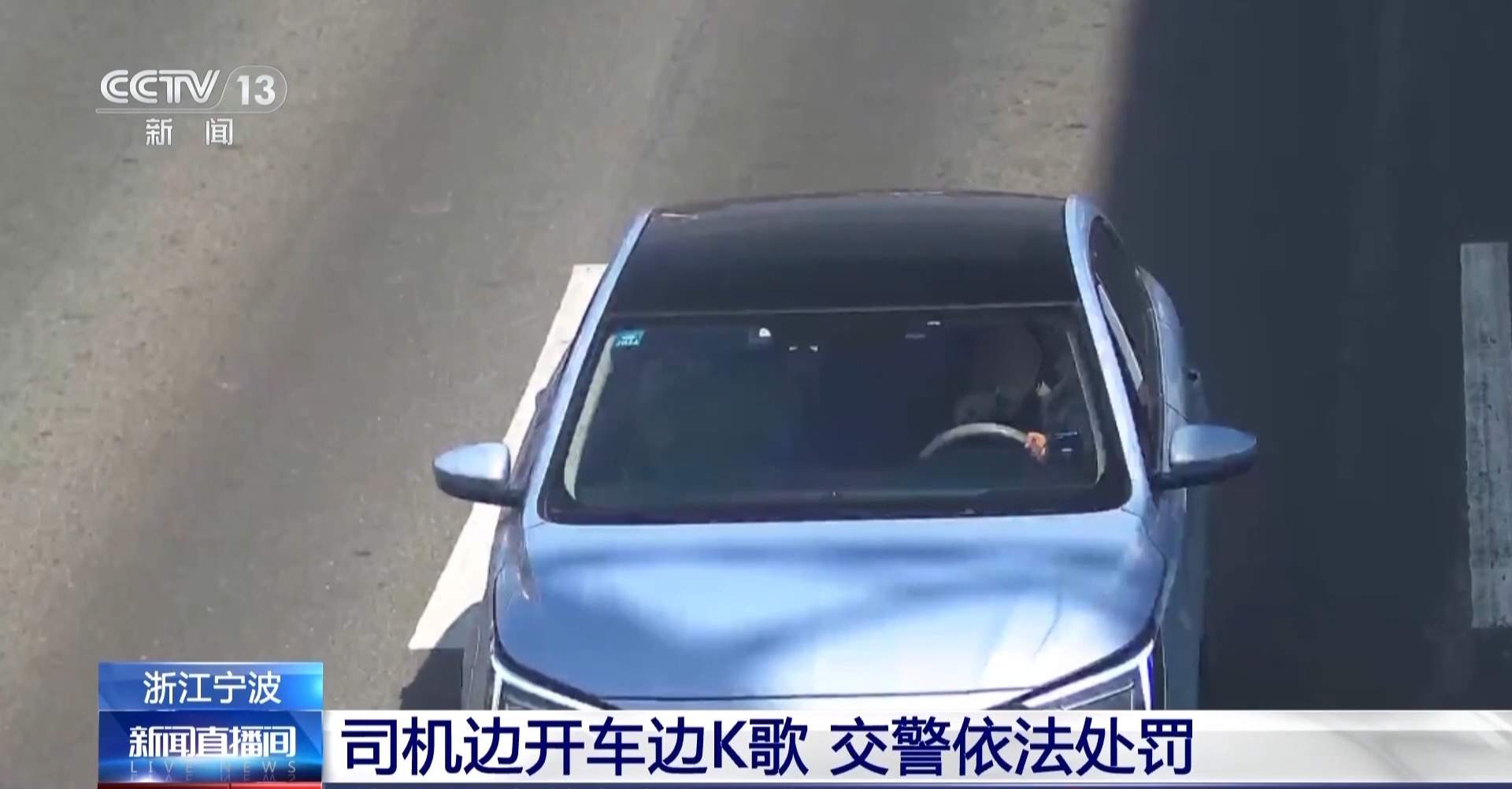 司机开车时手持麦克风唱歌 被交警依法处罚