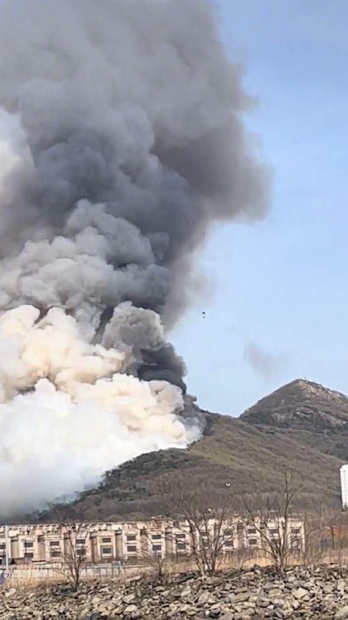 大连小窑湾山火已扑灭，无人员伤亡报告，此前火势迅速蔓延至山下街道，现场升起巨大烟柱，直升机就近取水在空中灭火