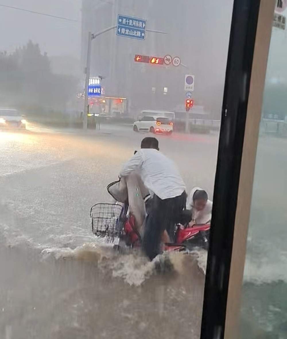 济南：暴雨天女子骑车带孩子摔倒，热心司机冒雨救助被困市民