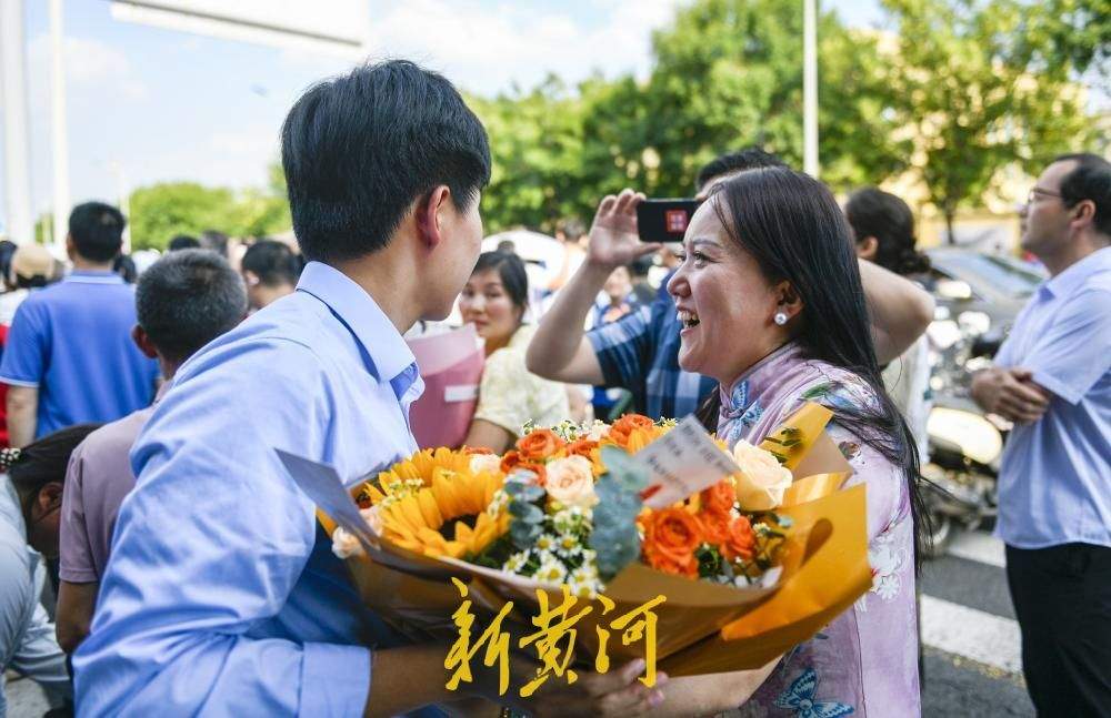 高考首批完成“闯关”考生笑着冲出考场 家长鲜花拥抱暖人心