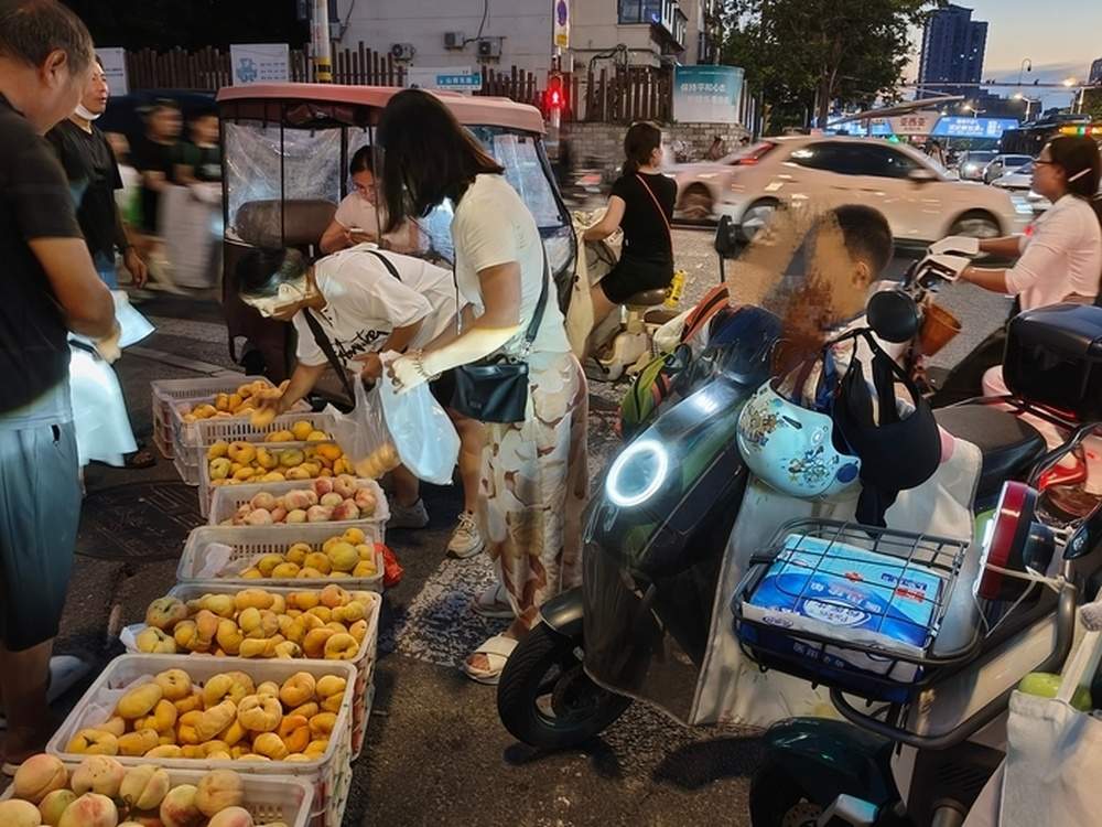 这个桃摊被爱心包围！跨城求医遇泉城善意，济南街头“卖桃救子”迎来转机