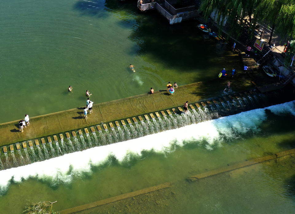 济南连续降雨后玉符河流水潺潺，孩子们尽情玩水
