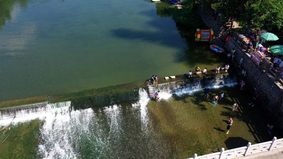济南连续降雨后玉符河流水潺潺，孩子们尽情玩水