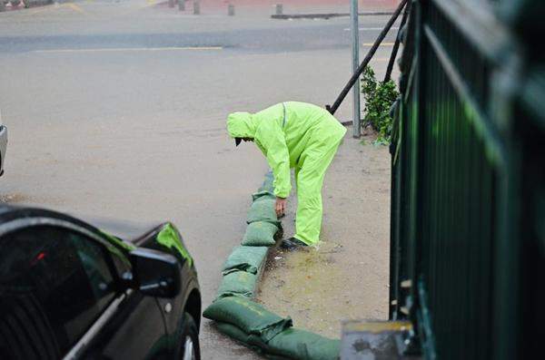 一幕触动人心的画面！地铁女员工暴雨天搬防洪沙袋获好评 