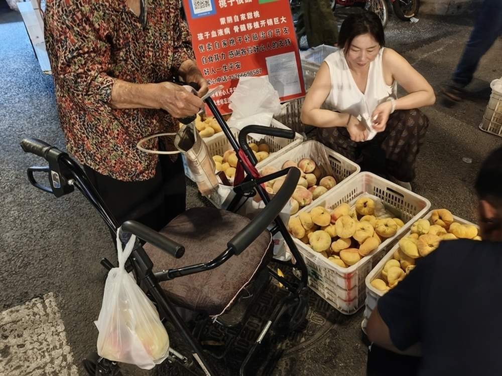 这个桃摊被爱心包围！跨城求医遇泉城善意，济南街头“卖桃救子”迎来转机