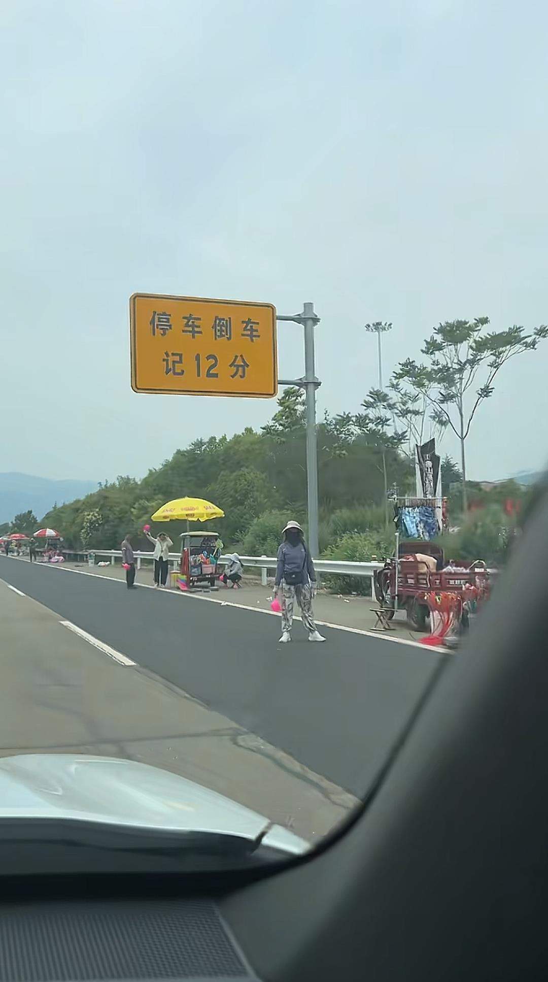 高速出口“停车倒车记12分”警示牌下竟有多名商贩卖水瓢,镇政府:系流动摊位,已多次劝离
