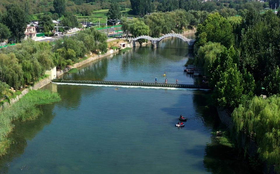 济南连续降雨后玉符河流水潺潺，孩子们尽情玩水