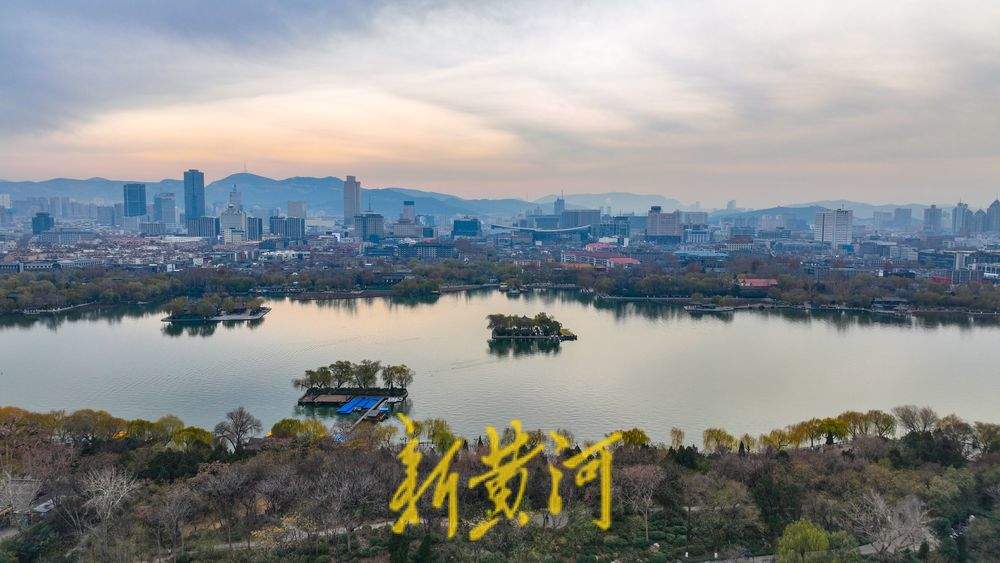 冷空气来袭，云层中暖光倒映大明湖