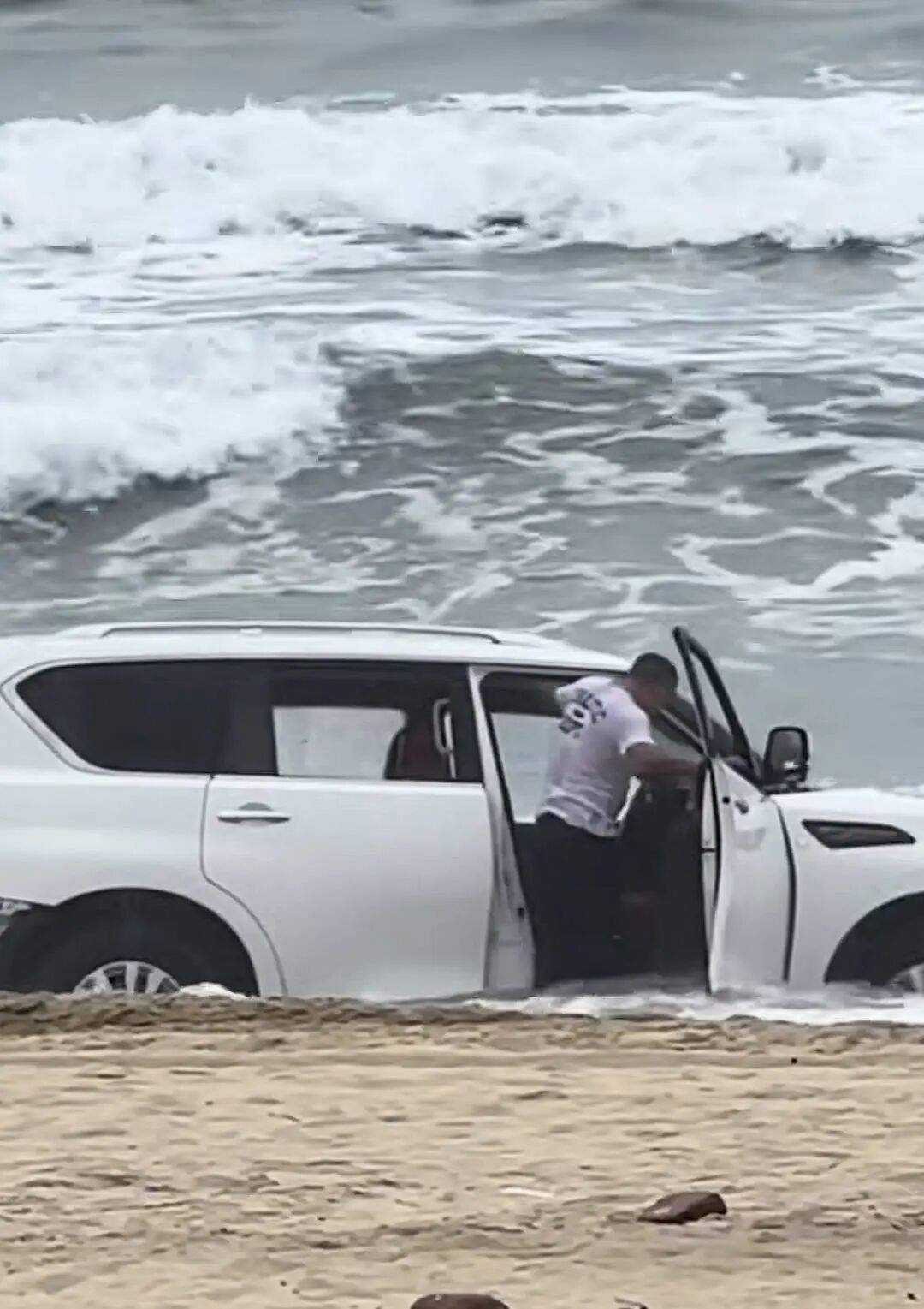 一越野车在沙滩“狂飙”,陷入沙里被海水淹没,司机紧急下车,当地回应