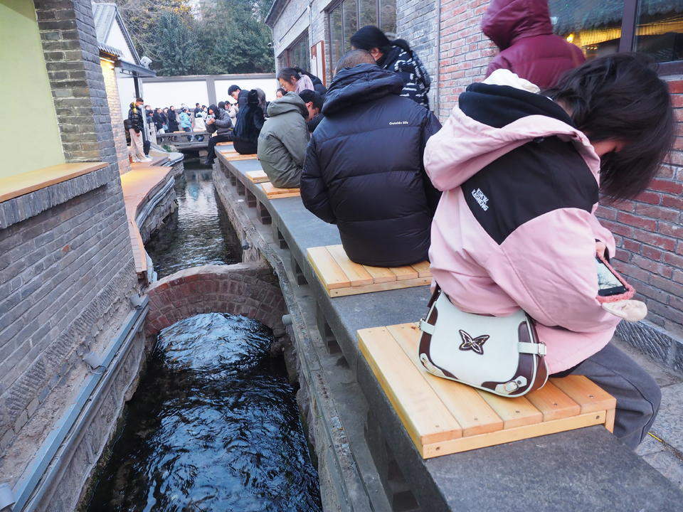 济南明府城泉河边，石栏新设木坐凳让游客听泉