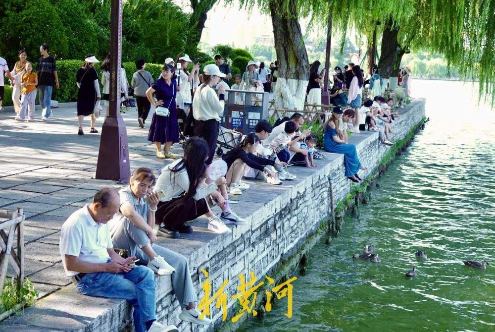 凉风习习，市民游客围坐湖堤享惬意“吹风时光”