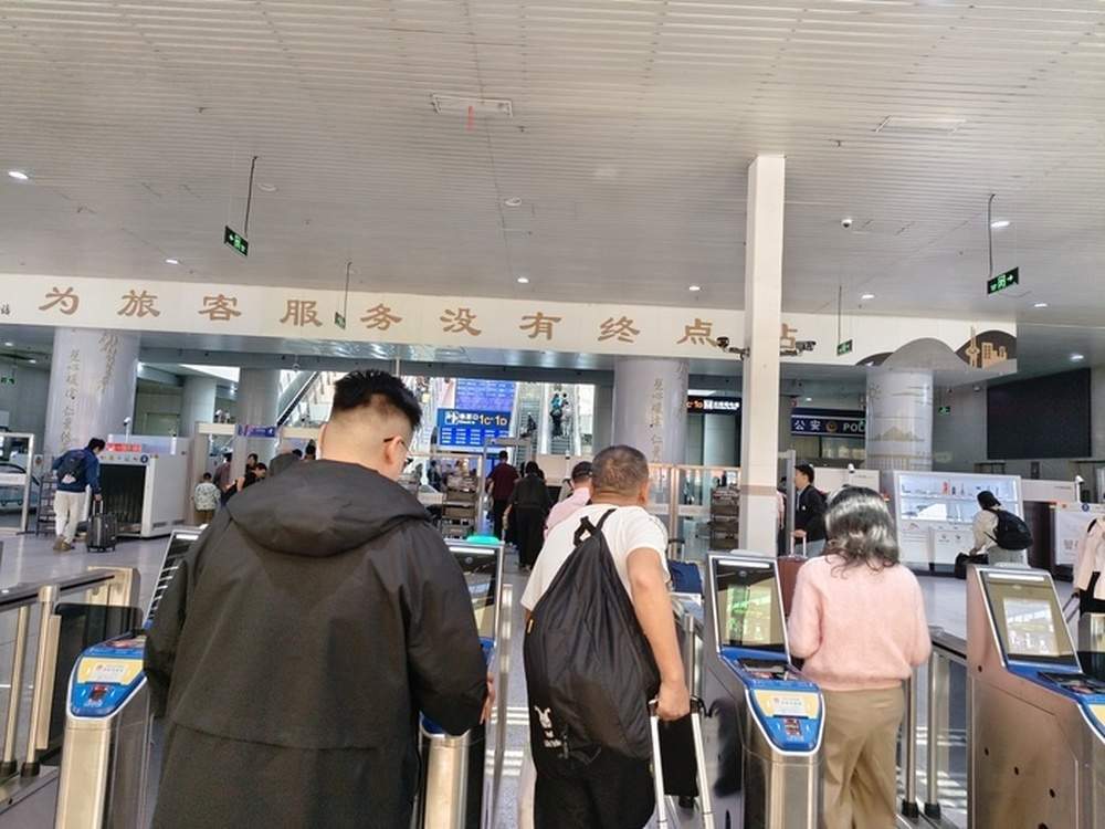 国庆首日济南站：行李箱上的鲜花，进站口前的长队