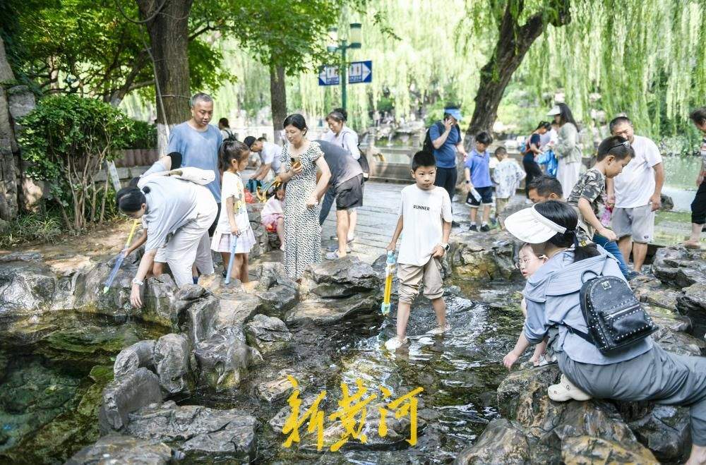 护城河畔汇波泉成夏日戏水乐园 泉水漫青石送来天然清凉