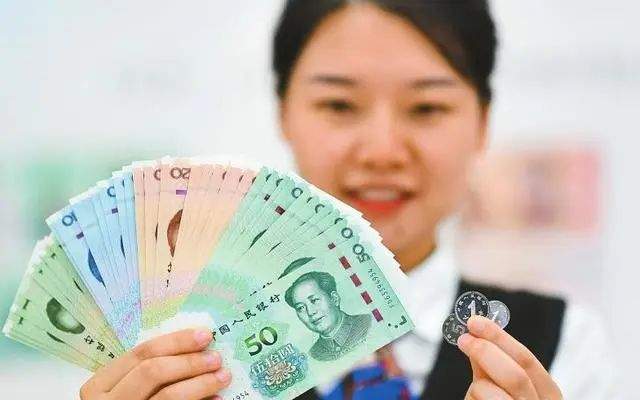 资料图:中国工商银行北京复兴门支行员工在展示2019年版第五套人民币.