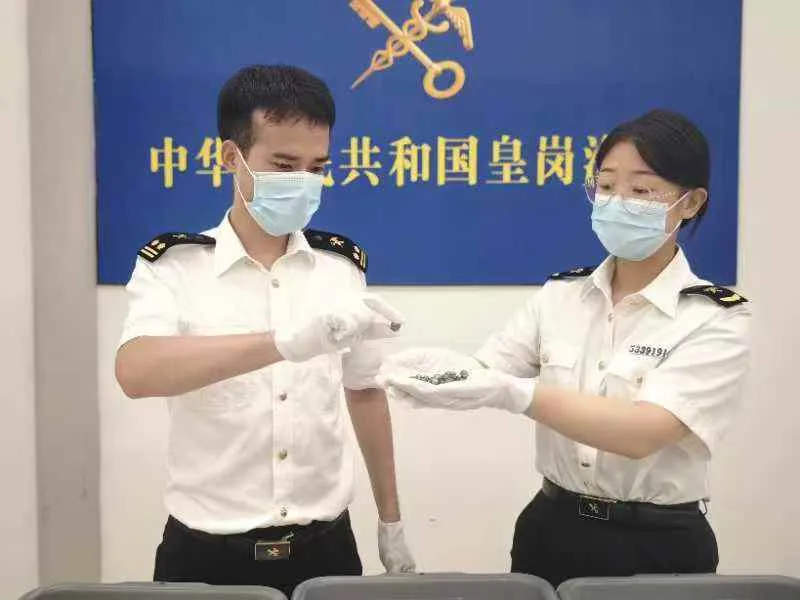 女子进境时神色紧张、举止异常！竟在胸部、裆部藏了626粒黑珍珠