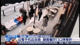 “低头族”在餐厅门口摔骨折 餐厅担责吗？