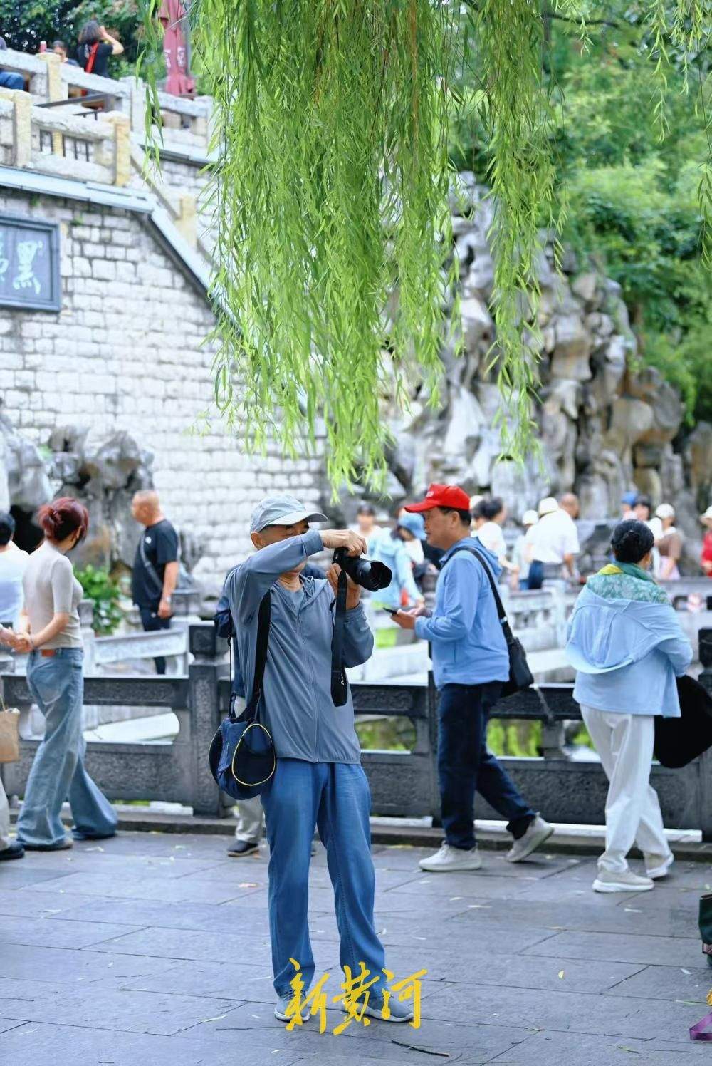 凉意来袭，市民游客换上秋装打卡护城河泉景