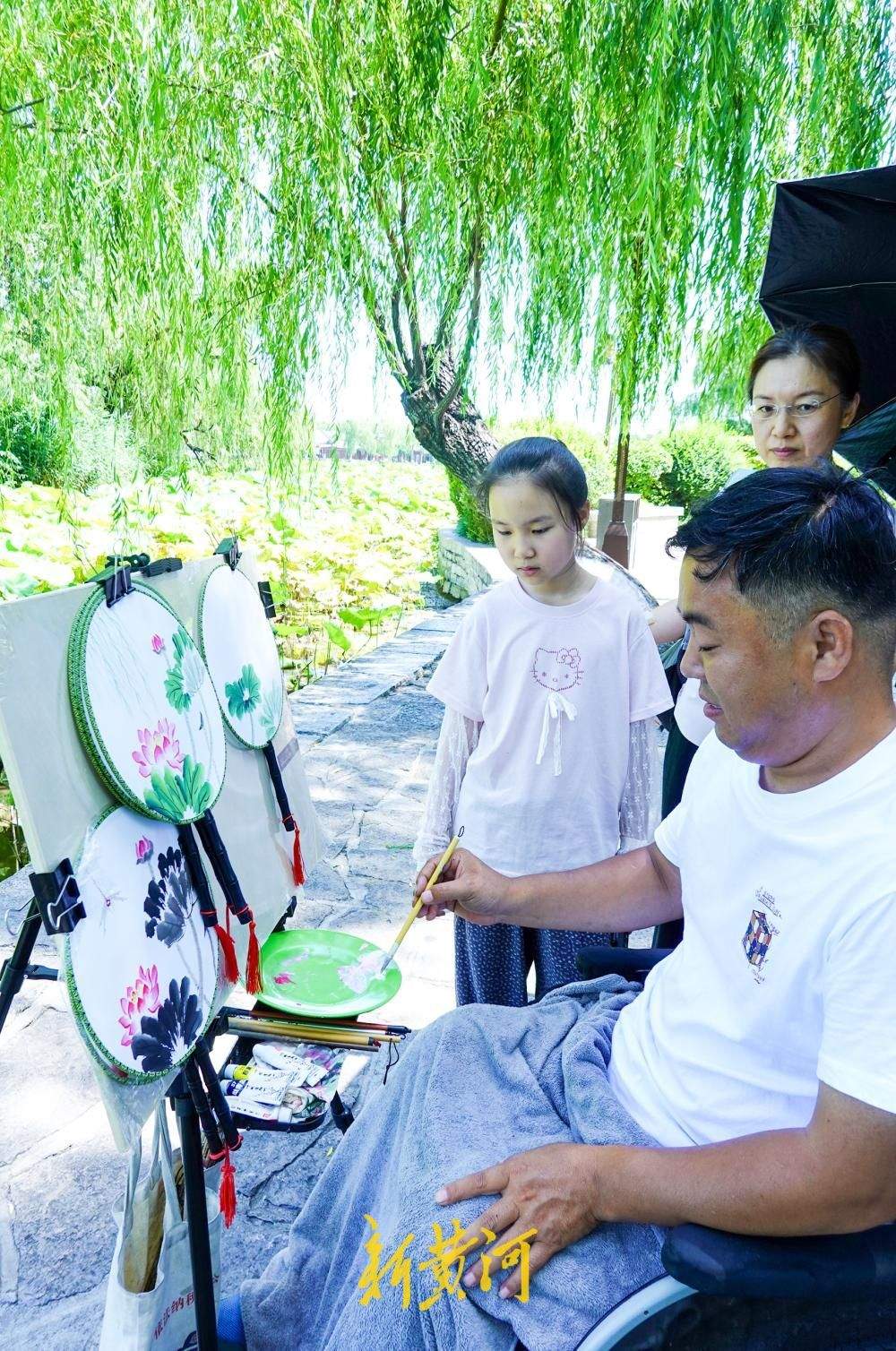 济南：轮椅上的画师做客大明湖畔 团扇上绘画荷花传递生命力量