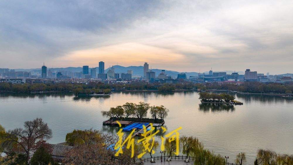 冷空气来袭，云层中暖光倒映大明湖